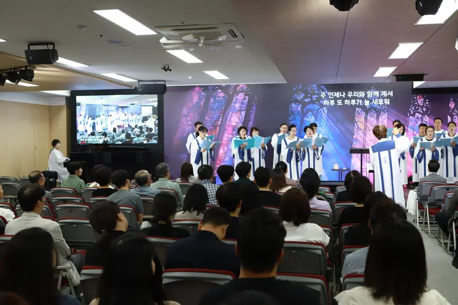 2025년 새 W홀에서 성가대 찬양을 듣는 성도들