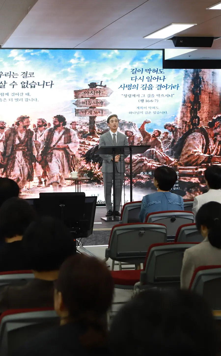 W홀에서 예배드리는 성도들의 뒷모습과 강단